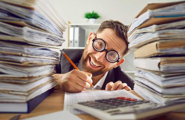 man surrounded by papers invoices