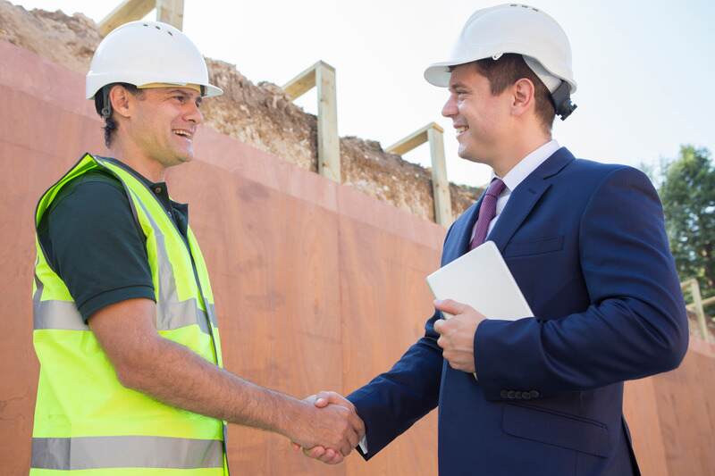 Homme d'affaires serrant la main d'un constructeur