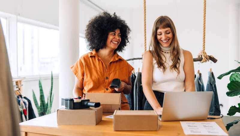 Happy clothing store owners working