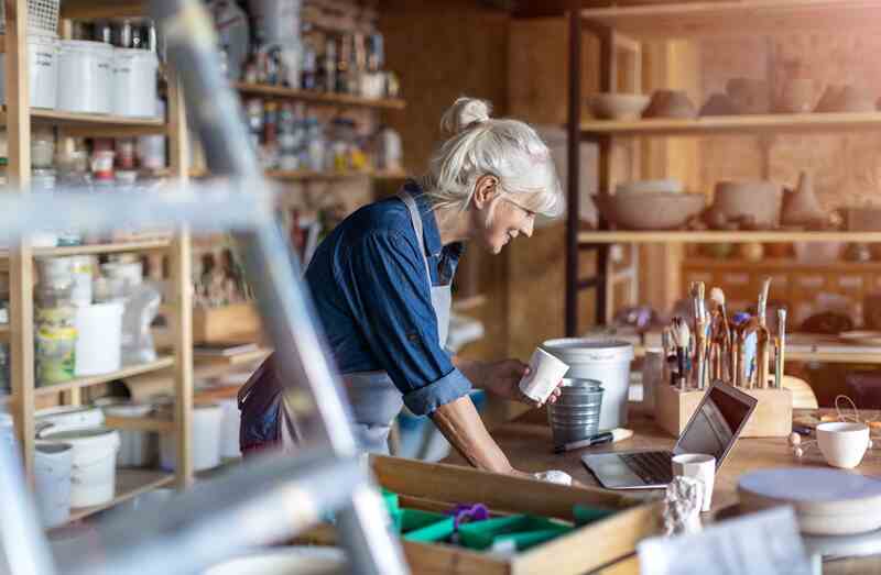 Small business owner senior female pottery artist in her art studio