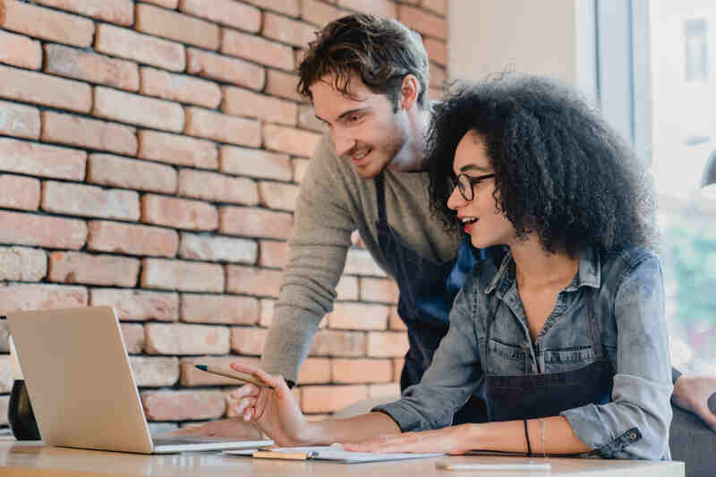 Les propriétaires de cafés utilisent un ordinateur portable pour leur comptabilité