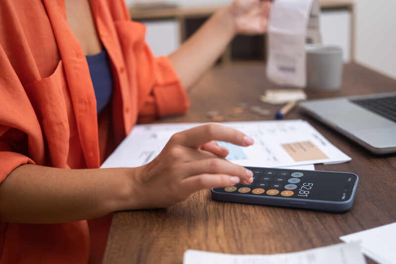 Budget Control woman manages finances using her smartphone calculator