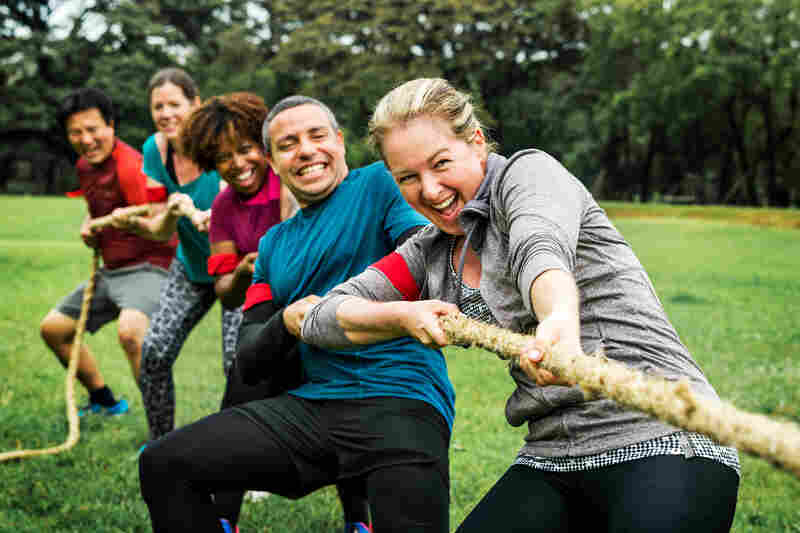 Equipo compitiendo en una actividad de tira y afloja en grupo reducido