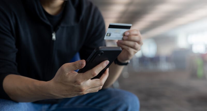 b2b payment concept man holding a credit card and a smartphone