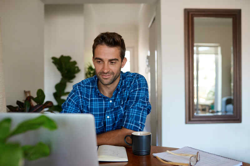 Joven trabajando desde casa con un portátil